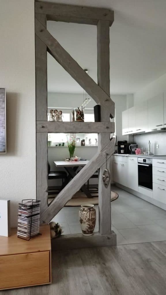 Raumteiler in der Küche in grau aus rusikalen Holzbalken
